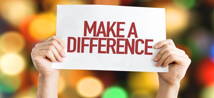 person holds a sign that says "make a difference"