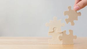 image of four wooden puzzle pieces being put together