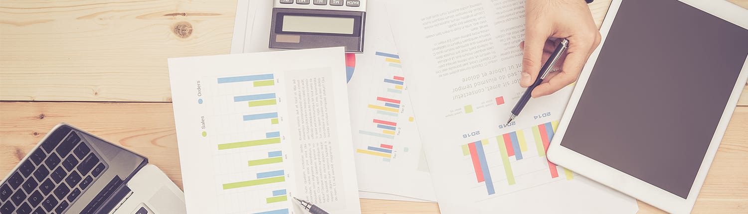 Image depicting data charts, calculations and tablet technology to indicate smart, informed, on-budget media buying.