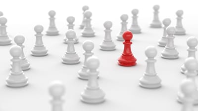 Image of a red chess piece in a crowd of white pieces, symbolizing brand differentiation.