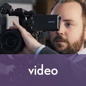 Image of videographer with camera, click to learn more about our video services